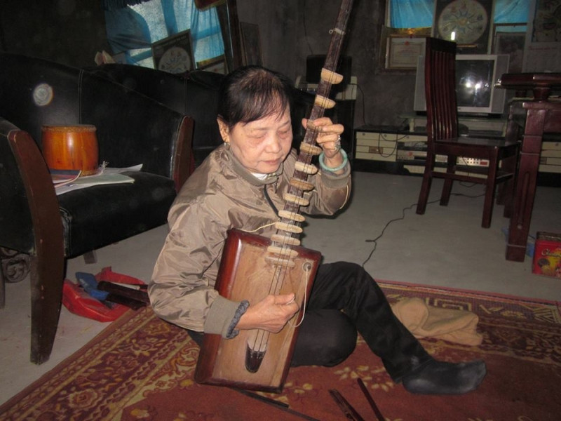 Nghệ nhân Nguyễn Thị Tam bên chiếc đàn đáy cổ