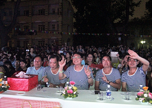 Thầy Bình( ngồi giữa) cùng các thầy cô trong trường mặc áo kẻ trong lễ tốt nghiệp của học sinh
