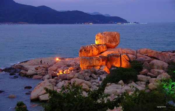 Khi màn đêm buông xuống, những ánh đèn phủ lên phiến đá khổng lồ, khiến bỗng chốc chúng biến thành những viên than hồng lấp lánh.