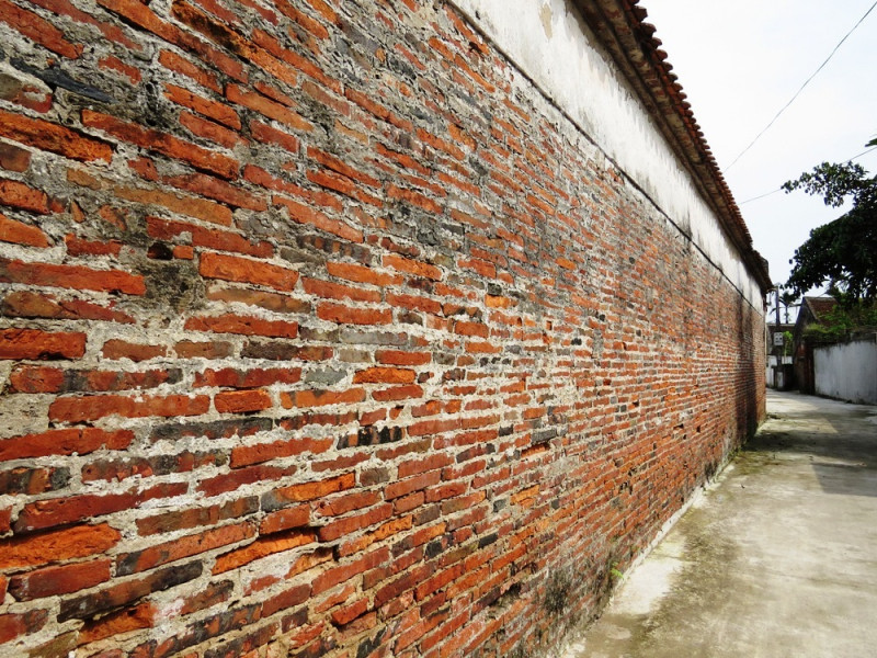 Tường nhà được xây bằng gạch đất nung bản mỏng, kích thước mỗi viên gạch dài tới 40 cm, rộng 30 cm