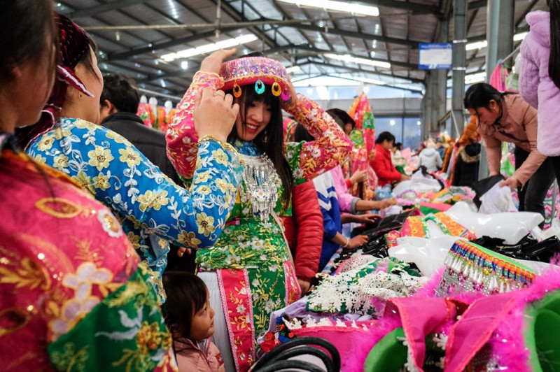Một cô gái đang thử khăn đội đầu, loại trang sức truyền thống của người dân tộc Mông thường được sử dụng trong các dịp lễ hội.