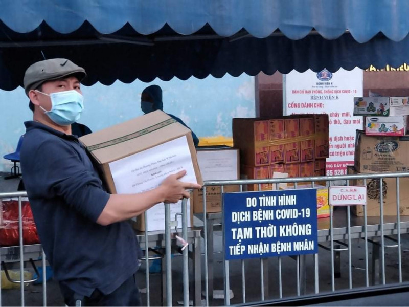 Phó giáo sư, tiến sĩ, bác sĩ Hoàng Bùi Hải đang bê những thùng dầu gội Hương Xưa cho bệnh nhân Bệnh viện K.