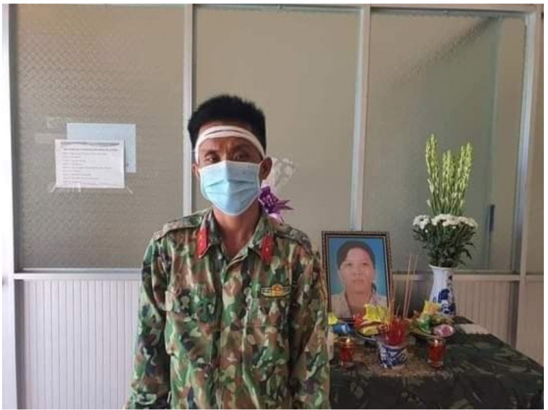 Trung sĩ Phùng Minh Phục bên di ảnh mẹ - Ảnh từ mạng xã hội